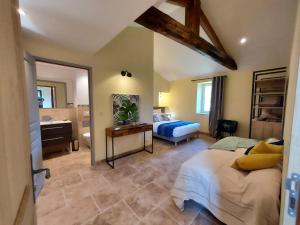 a bedroom with a bed and a bathroom with a sink at Les Jardins de Falguière in Saint-Jean-du-Gard