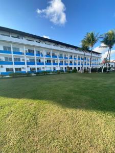 un grande edificio bianco con palme di fronte di Marinas Tamandaré a Tamandaré