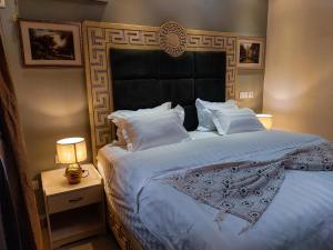 a bedroom with a large bed with a black headboard at Convivium Home Hotel in Douala +56 photos