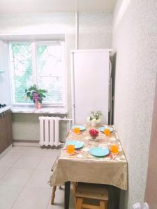 uma mesa com pratos e copos na cozinha em Светлые апартаменты в 100м от Софиевского парка em Uman