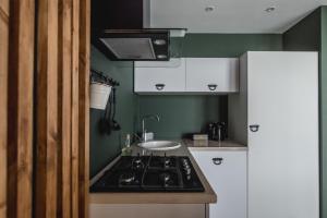 a small kitchen with a stove and a sink at WOODkz in Oral