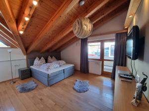 a living room with a bed and a television at Alpenapart Schultes Sports in Jerzens