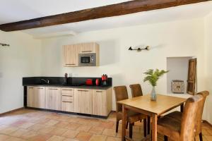 a kitchen with a wooden table and a dining room at Les Jardins de Falguière in Saint-Jean-du-Gard +109 photos