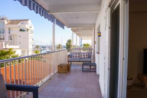 a balcony with a couch and a chair at Club Náutico Altea Playa in Altea