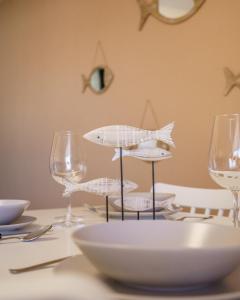 Club Náutico Altea Playa في ألتيا: طاولة مع حاملين للأسماك على طاولة مع كؤوس للنبيذ