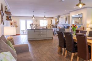 a kitchen and living room with a table and chairs at Sycamore Cottage in Penmaen-mawr