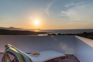 a view of the sunset from a balcony with a bed at Galini in Agia Irini Milos