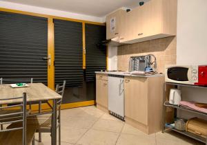 a kitchen with a table and a table and a microwave at La Chaumière d'Hérens in Vernamiège +11 photos