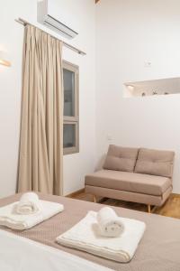 ein Zimmer mit einem Sofa und zwei Handtüchern auf dem Tisch in der Unterkunft Fragios Beach House in Chania