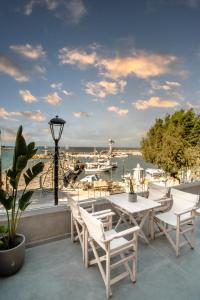 eine Terrasse mit einem Tisch und Stühlen sowie einem Hafen in der Unterkunft Fragios Beach House in Chania