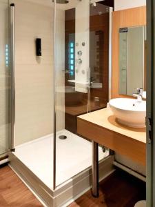 a bathroom with a glass shower and a sink at B&B HOTEL Cambrai in Cambrai