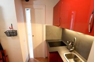 a kitchen with red cabinets and a sink at Grottino - Campo de' Fiori in Rome