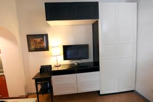 a living room with a tv and a desk with a lamp at Grottino - Campo de' Fiori in Rome