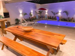 uma mesa de madeira numa sala de estar com piscina em Casa com piscina privativa na Praia do Peró em Cabo Frio