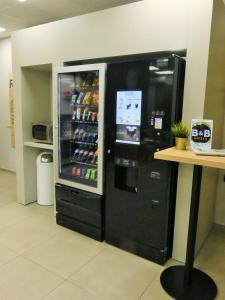 - un grand réfrigérateur noir à côté d'une table dans un magasin dans l'établissement B&B HOTEL Cambrai, à Cambrai