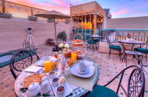 een tafel met eten en drinken op een patio bij riad paradis blanc in Marrakesh