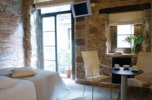 1 dormitorio con 1 cama, mesa y sillas en AinB Picasso-Corders Apartments, en Barcelona