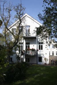 a white house with a balcony with flowers on it at Pension Mitte in Oldenburg