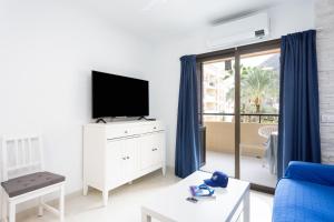 a living room with a tv and a blue couch at Listen THE STARS 505 - Los cristianos in Los Cristianos