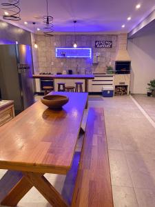 uma grande cozinha com uma mesa de madeira num quarto em Casa com piscina privativa na Praia do Peró em Cabo Frio