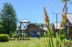 un parque infantil en un patio con cenador en Condominio Aliwén Cabañas en Malalcahuello