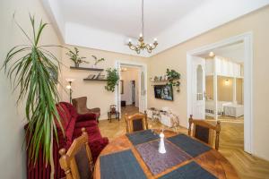 een woonkamer met een tafel en een bank bij Vintage Apartment in Pécs