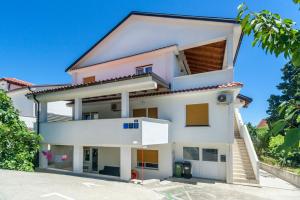 a white house with a red roof at Apartments & Rooms Strčić Krk in Krk