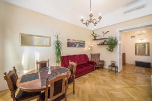 een woonkamer met een rode bank en een tafel bij Vintage Apartment in Pécs