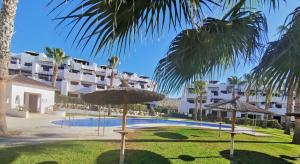 ośrodek z basenem oraz palmami i parasolami w obiekcie Sol y Alma Mediterranean Apartment w mieście Vera