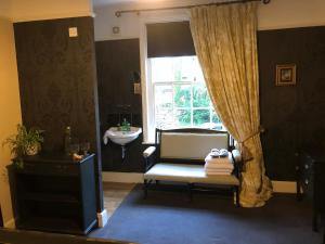 a room with a chair and a window and a sink at Traditional 18th Century Farmhouse in Streatley in Streatley