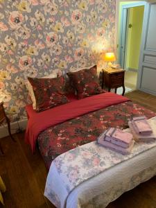 Schlafzimmer mit einem Bett mit Blumentapete in der Unterkunft Villa l'INSOUCIANCE en Champagne in Vincelles