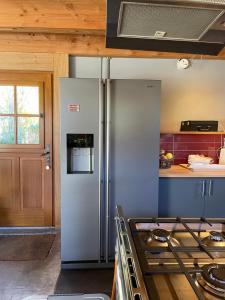 a kitchen with a stainless steel refrigerator and a counter at CHALET LA BOLLINE in Valdeblore