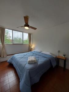 a bedroom with a blue bed with a ceiling fan at Quinta Park in Mendoza