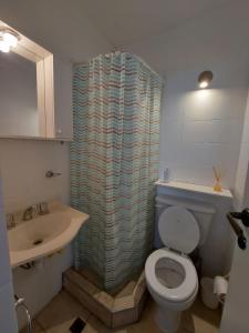 a bathroom with a shower curtain and a toilet at Quinta Park in Mendoza