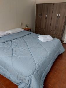 a bedroom with a blue bed with two towels on it at Quinta Park in Mendoza