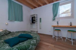 1 dormitorio con 1 cama y 2 taburetes en L'alba di ortigia a due passi dal mare, en Siracusa