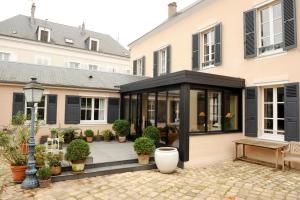 une extension d'une maison avec portes et fenêtres noires dans l'établissement Le Jardin Cathedrale, à Chartres