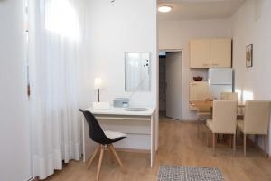 a room with a table and a chair and a kitchen at Studio apartman Rossa in Daruvar