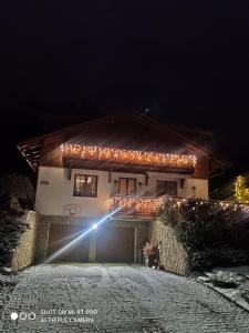 a house with lights on the side of it at night at Margus Apartmány in Oščadnica