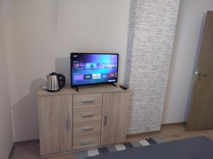 a flat screen tv sitting on top of a wooden cabinet at St John Park Boutique room Gero in Bansko