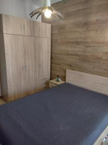 1 dormitorio con 1 cama y paredes de madera en St John Park Boutique room Gero, en Bansko