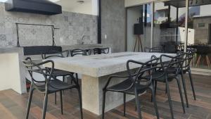 a large marble table with black chairs in a room at New House with Private Pool in Manzanillo