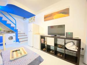 a living room with a tv and a staircase at Bungalow Playmar in Playa del Ingles