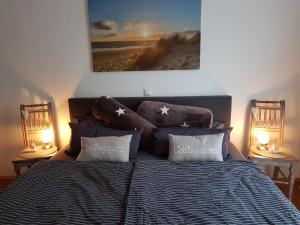 een slaapkamer met een bed met kussens en 2 lampen bij Lavendel in Bornheim