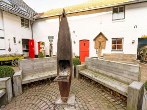 a wooden boat sitting next to two wooden benches at Beautiful holiday home in Voerendaal in Voerendaal