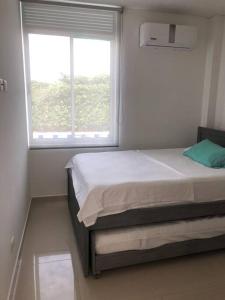 a small bedroom with a bed and a window at Villa Juliana in Carmen de Apicalá +11 photos