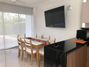 a kitchen with a table with chairs and a television at Villa Juliana in Carmen de Apicalá