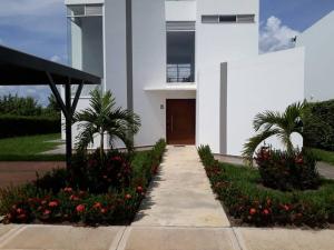 a white building with flowers and a walkway at Villa Juliana in Carmen de Apicalá