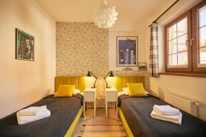 2 letti in una piccola camera con cuscini gialli di SeaYou Yellow House a Rogowo Altre 65 foto