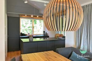 a kitchen with a table and a large chandelier at Purer Luxus am Samerberg mit Sauna & Kamin in Samerberg